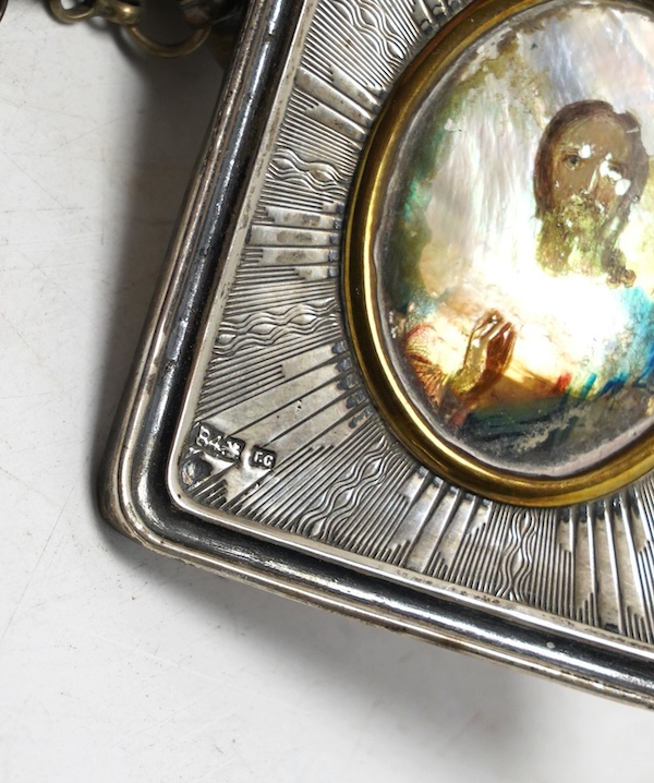 A Greek white metal pendant, embossed with St. George and the dragon, on a chain and a Russian white metal framed portrait of Christ. Condition - poor to fair